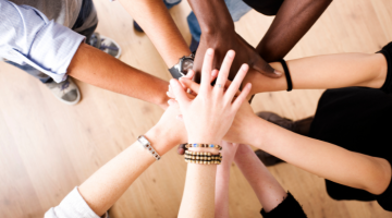 Hands reaching into the centre demonstrating teamwork